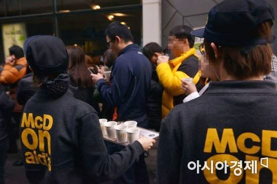 맥도날드 직원이 대기 중인 고객에게 따뜻한 커피를 제공하고 있다.