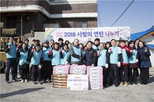 13일 김용익 국민건강보험공단 이사장(앞줄 가운데)을 비롯한 공단 임직원들이 원주 지역에 연탄 3만장을 기증하고 학성동 일대 10가구에 연탄을 전달한 뒤 기념사진을 촬영하고 있다.