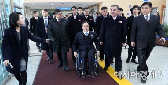 평창 패럴림픽 북한 선수단장 정현 조선장애자포호연맹 부위원장과 대표단장 김문철 위원장(횔체어 오른쪽) 등 24명이 남측 임찬규 패럴림픽국장과(가운데 휠체어) 함께 7일 경기도 파주시 남북출입사무소를 통해 남쪽으로 넘어오고 있다./파주=사진공동취재단