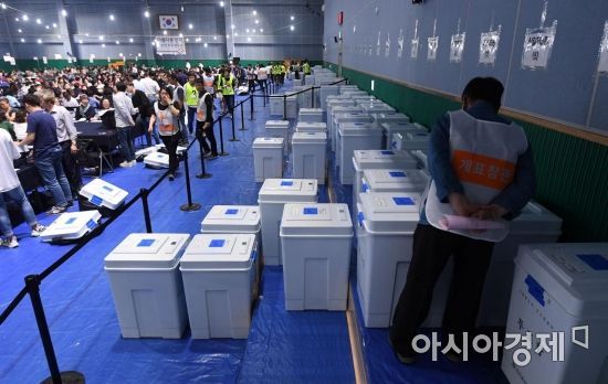 제7회 전국동시지방선거 및 국회의원 재ㆍ보궐선거가 치러진 13일 서울 영등포다목적배드민턴체육관에 설치된 영등포구선거관리위원회 개표소에서 개표 참관인이 투표함을 살펴보고 있다./김현민 기자 kimhyun81@