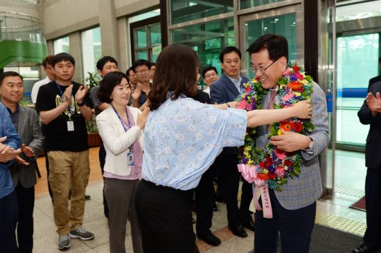 유덕열 동대문구청장이 14일 출근길에 직원들의 꽃다발을 받고 즐거워하고 있다.