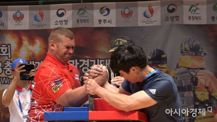 제13회 충주세계소방관경기대회 팔씨름 경기에서 40kg 차이를 극복하고 박빙의 승부를 펼치고 있는 체코 대표 피터 소방대원(사진 왼쪽)과 창원소방본부 소속 김태헌 소방사(사진 오른쪽).