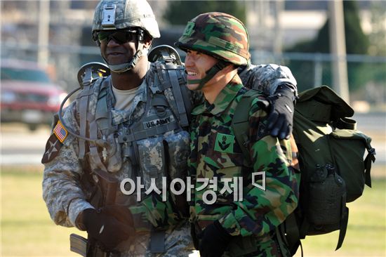 행군을 마친 미군 2대대 버글 대대장과 한국군지원단 소속 홍종용 소령<학사35기>이 서로를 축하해주고 있다.
