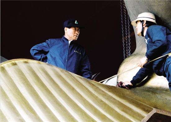 1983년 10월 14일 작업용 타워에 올라온 정주영 현대중공업 회장이 선박 프로펠러를 검사하고 있는 김명웅 직원(오른쪽)과 대화를 나누고 있다.