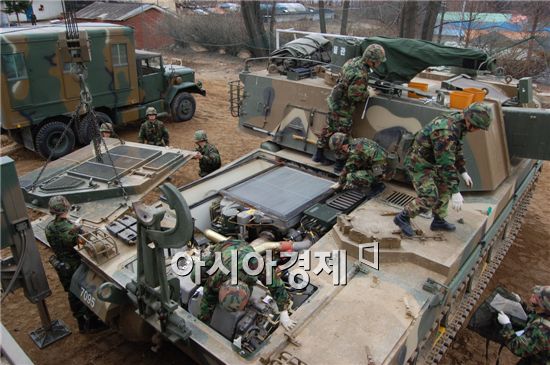 K-912구난차량이 K-9자주포에서 1000마력의 엔진을 꺼내기 위해 상판을 제거하고 있다.