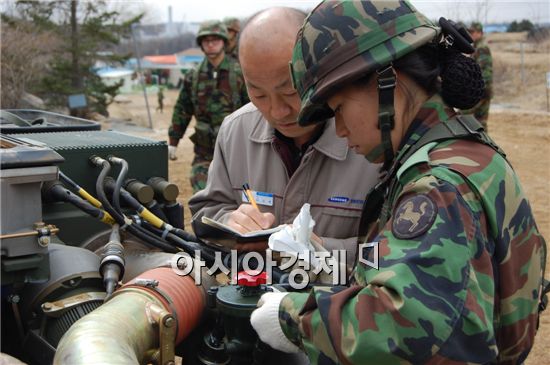 삼성테크윈 김상복 엔지니어와 전군 유일의 K-9자주포 여군 정비대장이 정비항목을 꼼꼼히 살피고 있다.