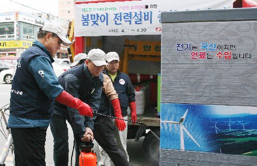 지난 4월11일 전기의 날에 김쌍수 사장(왼쪽)이 직원들과 마포구 일대 거리의 지상 변압기를  걸레와 세제를 이용하여 깨끗이 청소하고 있다