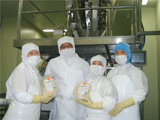 정년을 잊고 일하는 즐거움에 살고 있는 57~60세 직원들이 공장에서 생산되는 돈까스 제품을 들고 최선근 대표(왼쪽에서 두 번째)와 함께 기념촬영을 하고 있다.