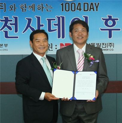 장도수 사장(왼쪽)이 희망지킴이 천사운동본부 김지욱 본부장과 후원약정서를 들어보이고 있다.