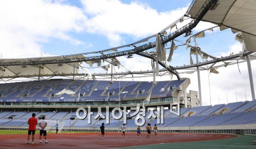 2일 오전 인천 남구 문학경기장 주경기장 지붕막이 제 7호 태풍 곤파스의 영향으로 심각하게 파손된 가운데 운동선수들이 운동을 하고 있다./ 인천=이기범 기자 metro83@
