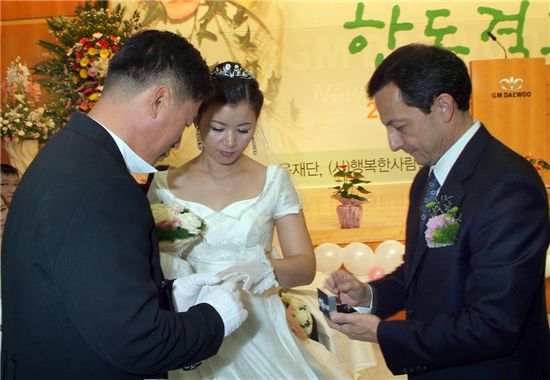 마이크 아카몬 사장이 2일 GM대우 부평본사에서 열린 합동결혼식에서 신랑과 신부에게 결혼 예물 반지를 전달하고 있다.
