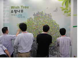 소망나무에 '소망'을 적고 있는 사람들.