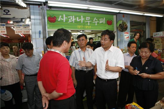 김우영 은평구청장(오른쪽)이 시장을 찾아 상인들 애로사항을 듣고 대책을 설명하고 있다.