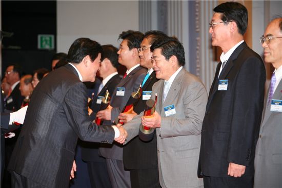 김기동 광진구청장(오른쪽)이 최경환 지식경제부장관으로 부터 상패를 받고 기뻐하고 있다.
