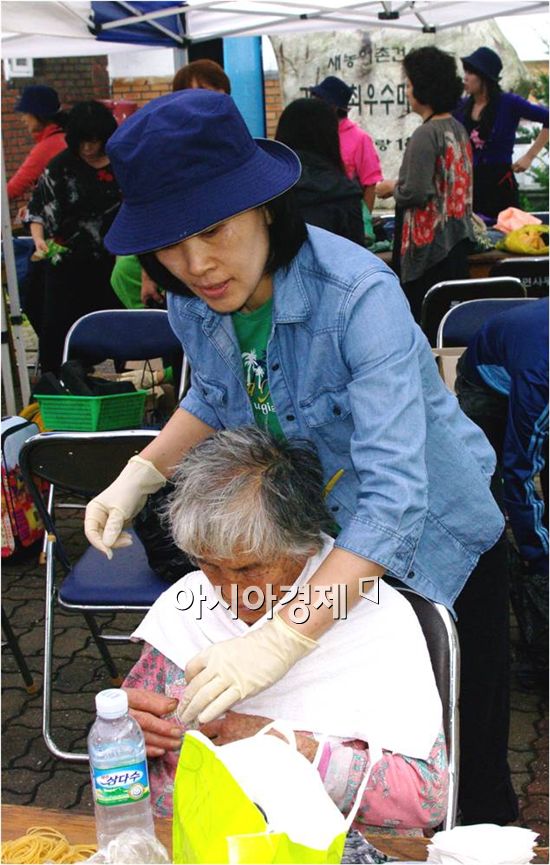 변남숙 원장(동현 미용실)이 강원도 양구군 대암산 지게마을 봉사활동에서 노인들의 머리를 손질하고 있다.