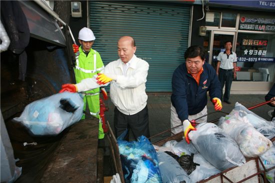 이만의 환경부장관(가운데)와 조길형 영등포구청장이 쓰레기를 차에 실고 있다.