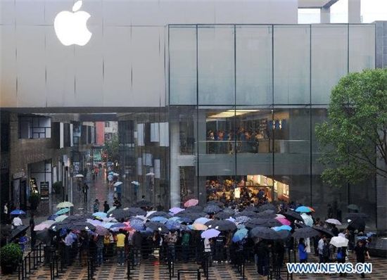 17일(현지시간) 비가 내리는 가운데 베이징 싼리툰에 위치한 애플 매장이 아이패드를 구입하려는 사람들로 북적거리고 있다.