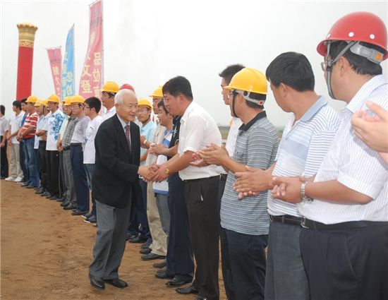민계식 현대중공업 회장(가운데 검정 양복 상의)이 지난 19일 중국 산둥성 웨이하이시에 건설 중인 풍력 공장 현장을 방문해 현지 직원들과 악수하고 있다.