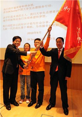 박용주 SK텔레콤 CSR실장(사진 왼쪽 첫번째)와 판핑 중국 공천단 광화과학기술기금회 부비서장(사진 왼쪽 네번째)과 SK써니 학생 대표들이 자원봉사단기를 흔들고 있다.