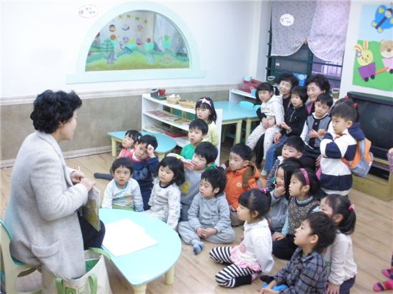 명성어린이집 아이들에게 책을 읽어주는 자원봉사자.