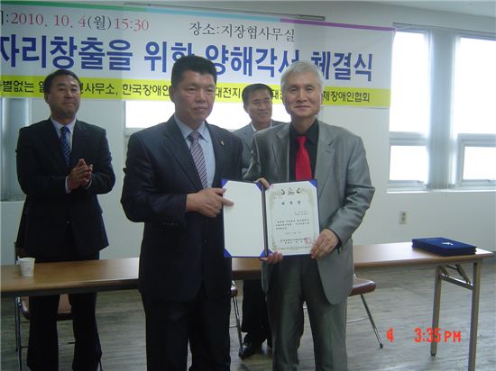 윤석연 대전광역시지체장애인협회장과 왕성상 아시아경제신문 본부장(오른쪽)이 자문위원 위촉장 전달식을 갖고 포즈를 취했다.