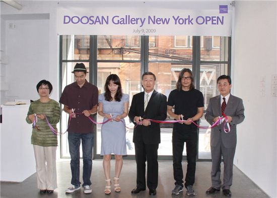 박용현 두산 회장(오른쪽에서 세번째)이 지난해 7월 문을 연 미국 두산갤러리뉴욕 개관 행사에서 참석자들과 테이프 커팅을 하고 있다.