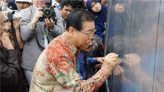 정준양 포스코 회장이 지난달 28일 인도네시아 반탐주 찔레곤시에서 열린 고로 일관제철소 부지공사 착공식에서 방명록에 인사말을 적고 있다.