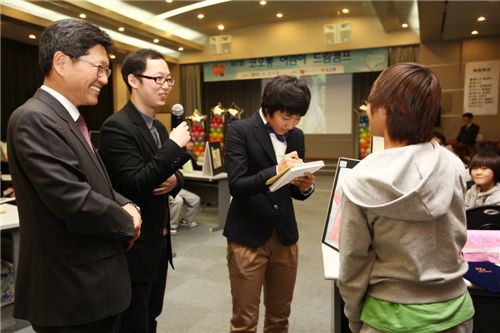 11월 2~3일 열린 코오롱어린이드림캠프에서 (주)코오롱 김남수 사장과 유소년 여자축구 국가대표 여민지 선수가 장학생에게 장학증서를 수여, 여민지 선수는 사인을 해주고 있다.