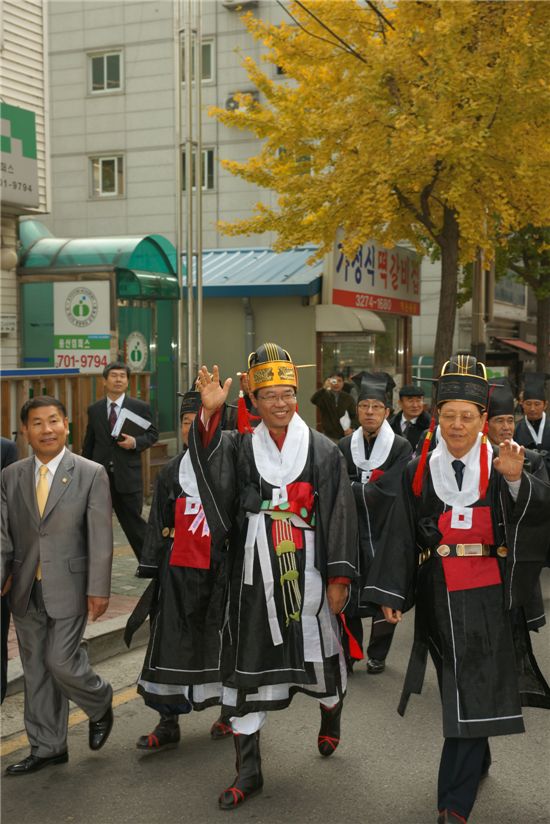 성장현 용산구청장이 거리 행진 중 주민들에게 손을 들어 인사하고 있다.