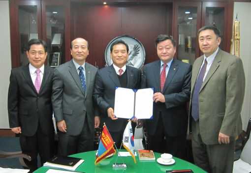 장도수 사장(가운데)이 몽골 교육문화부 장관(장 사장 오른쪽)과 MOU를 서명한뒤 들어보고 있다.