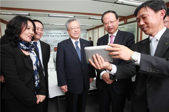 왕젠저우 차이나모바일 회장(사진 오른쪽에서 두번째)이 홈태블릿폰을 통해 인기 걸그룹 미쓰에이의 중국인 멤버들과 화상통화하고 있다.