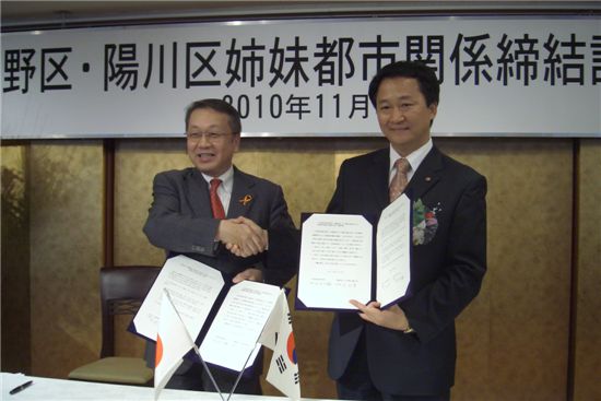 이제학 양천구청장(오른쪽)과 일본 나카노구 타나카 다이스케 구장이 자매결연서에 사인한 후 악수하고 있다.

