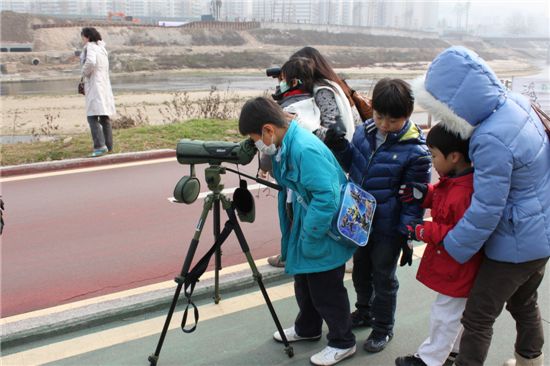 어린이들이 중랑천에 날아온 겨울 철새를 관찰하고 있다.