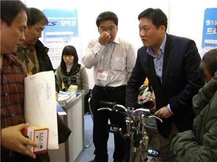 김상구 티앤에스모터스 이사가 3초 만에 쉽게 접히는 친환경 모야2 전기자전거를 관람객들에게 설명하고 있다. 이 전기자전거는 국내에서 가장 가볍고 1회 충전시 최대 30km까지 이동이 가능하다는 게 회사측 설명이다.  
