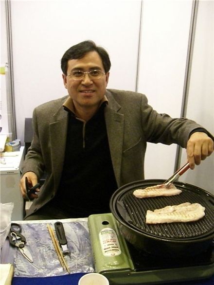 박용일 성우엘앤텍 대표가 석화구이 석쇠를 이용, 고기를 굽고 있다.