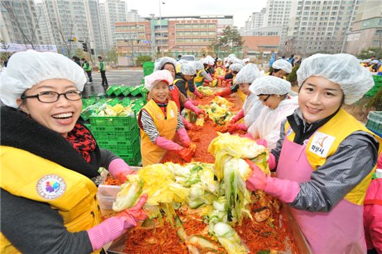 삼성전자 사랑나눔 김장축제에 참여한 삼성전자 임직원들이 정성껏 담근 김치를 들어보이고 있다.