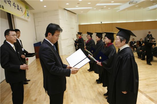 김우영 은평구청장이 24일 주민자치대학 수료식에서 수료증을 주고 있다.