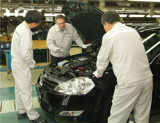 장 마리 위르띠제 사장(가운데)을 포함한 르노삼성 직원들이 생산된 차량의 품질을 점검하고 있다.