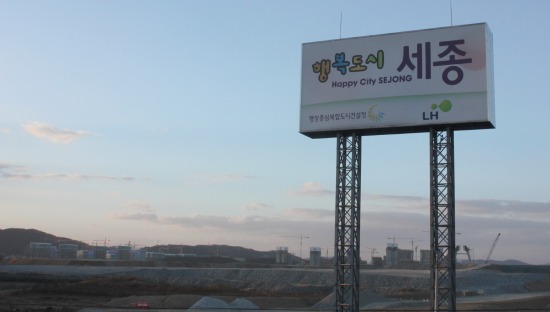 2012년부터 국무총리실을 비롯 36개 기관이 들어서는 세종시. 조치원~대전 간 국도변에 서 있는 안내판 뒤로 첫마을아파트 건설현장 모습이 보인다.