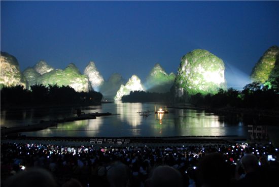 류산지에(劉三姐) 공연, 어두워지면 수변의 봉우리에 조명이 비춰 아름다운 무대를 만들어낸다.