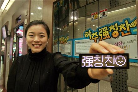 아주강(强)칭찬 캠페인의 첫 주 우승자인 아주캐피탈 마케팅팀 이정미 대리가 칭찬명찰을 선보이면서 활짝 웃고 있다.