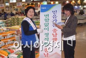아시아경제신문이 만든 '충남쌀 팔아주기' 홍보자료집을 펼쳐보고 있는 고객과 판매직원.