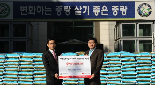 조흥원 서울우유 조합장(오른쪽)이 중랑구청에 4000만 원 상당의 쌀 900포를 전달하고 있다. 