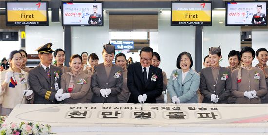 아시아나항공 윤영두 사장(우측 네번째) 및 아시아나 임직원들이 17일 인천국제공항 아시아나 탑승수속 카운터앞에서 1000만번째 아시아나 국제선 승객인 최미경씨(우측 세번째)와 대형 떡를 커팅하는 기념행사를 가지고 있다.
