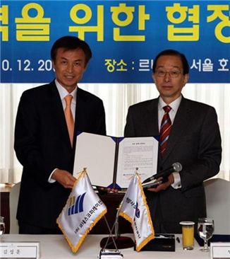 민계홍 이사장(왼쪽)과 김성훈 대표가 MOU를 체결한 뒤 들어보이고 있다