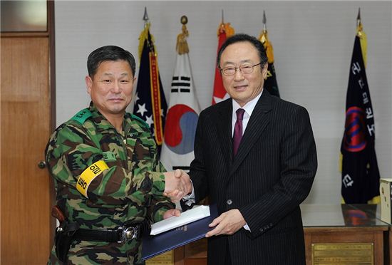 사공일 한국무역협회 회장(오른쪽)이 21일 이상현 보병 제7사단 소장에게 위문금을 전달하고 있다.

