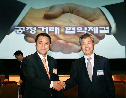 김쌍수 한전 사장(왼쪽)이 이재광 광명전기 대표와 공정거래 협약을 체결하고 협약서를 들어보이고 있다.