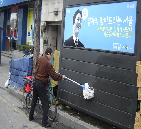 서울시 해치숍(가로판매대) 운영자가 시설물 세척을 하고 있다.