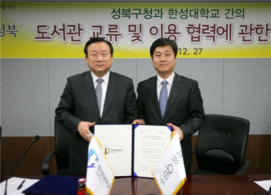 김영배 성북구청장과(오른쪽)과 정주택 한성대학교 총장이 ‘도서관 교류, 이용 협력에 관한 협약서’에 서명한 뒤, 이를 함께 들어 보이고 있다.

