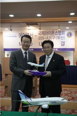 에어부산 김수천 대표(왼쪽)가 국제라이온스협회부산지구 이병재 총재(오른쪽)에게 에어부산 모형비행기를 기념품으로 전달하고 있다.
